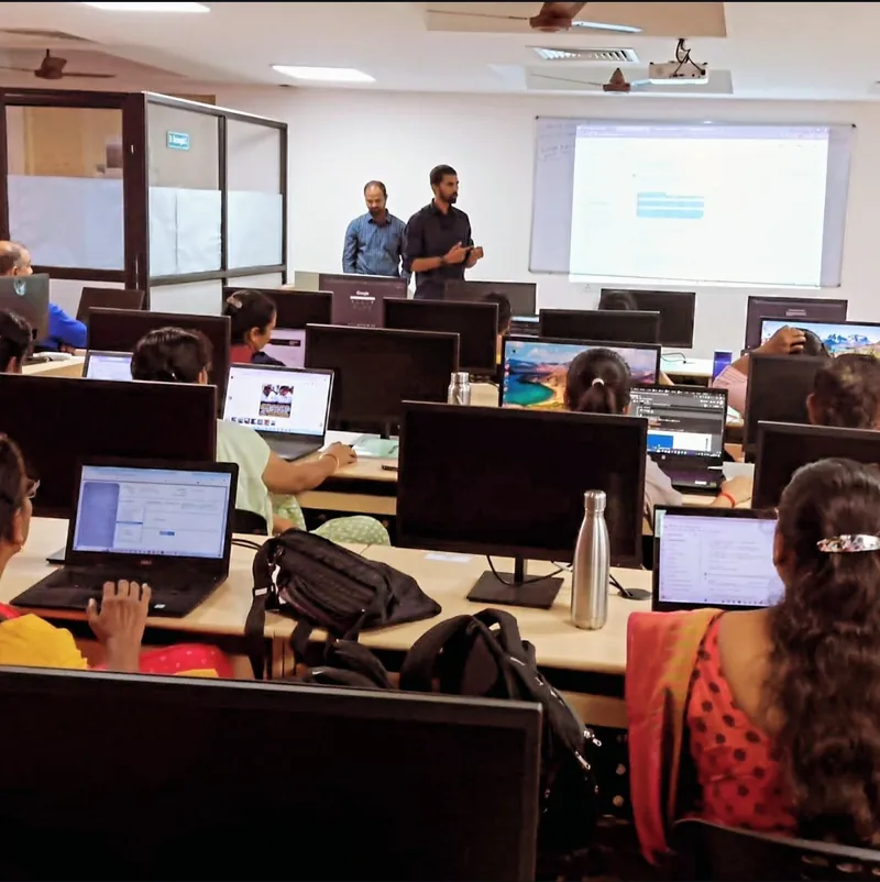 Haribaskar Dhanabalan presenting at the front of a computer lab during a hands-on workshop